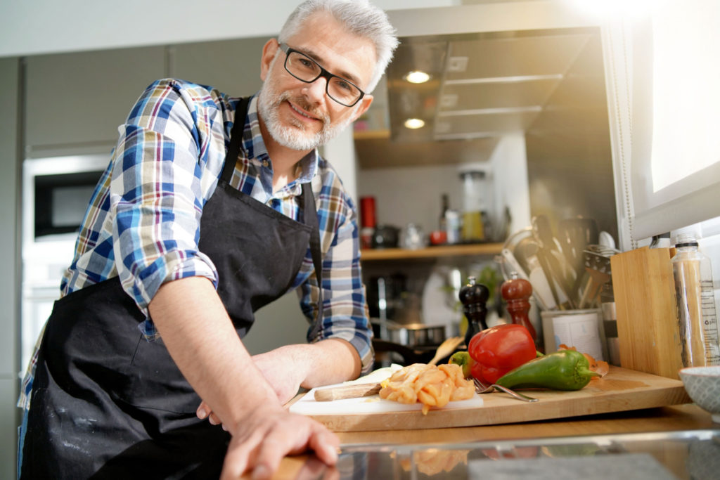 Cheerful mature man in kitchen preparing dish - Vorteilhaft Leben - Vorteilhaft Leben
