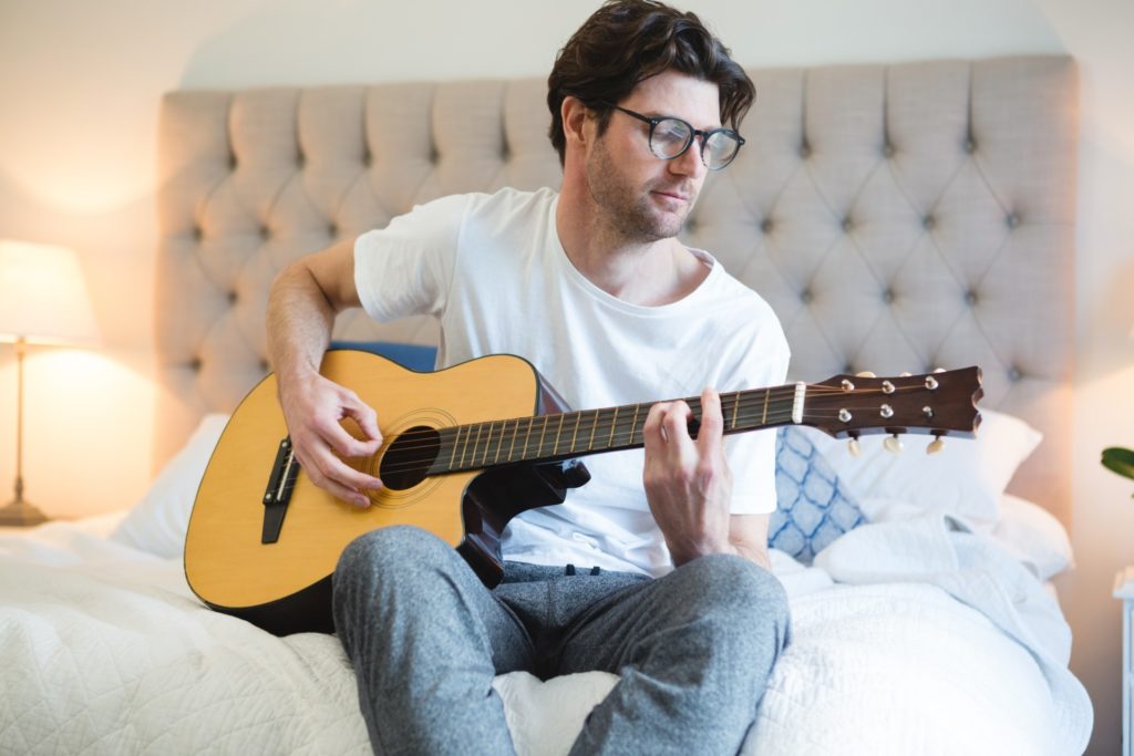 Man playing guitar in bedroom - Vorteilhaft Leben - Vorteilhaft Leben
