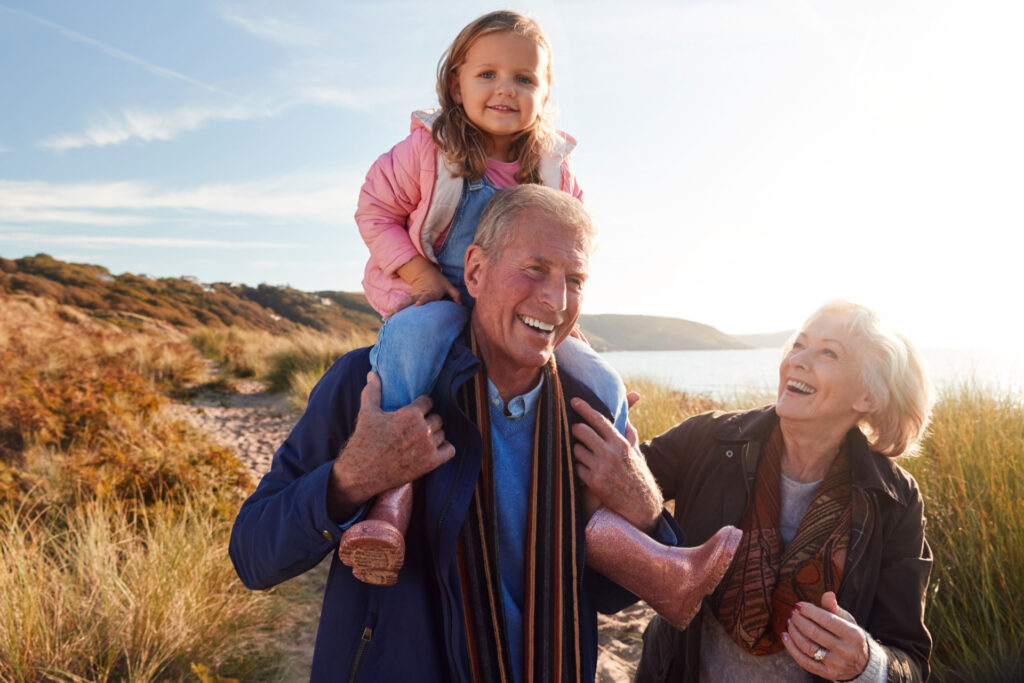 Aktiv und leistungsfähig bleiben, wer wünscht sich das nicht? Eine wichtige Voraussetzung ist eine ausreichende Vitamin-B12-Versorgung. Bild: Großeltern gehen mit Enkel spazieren.